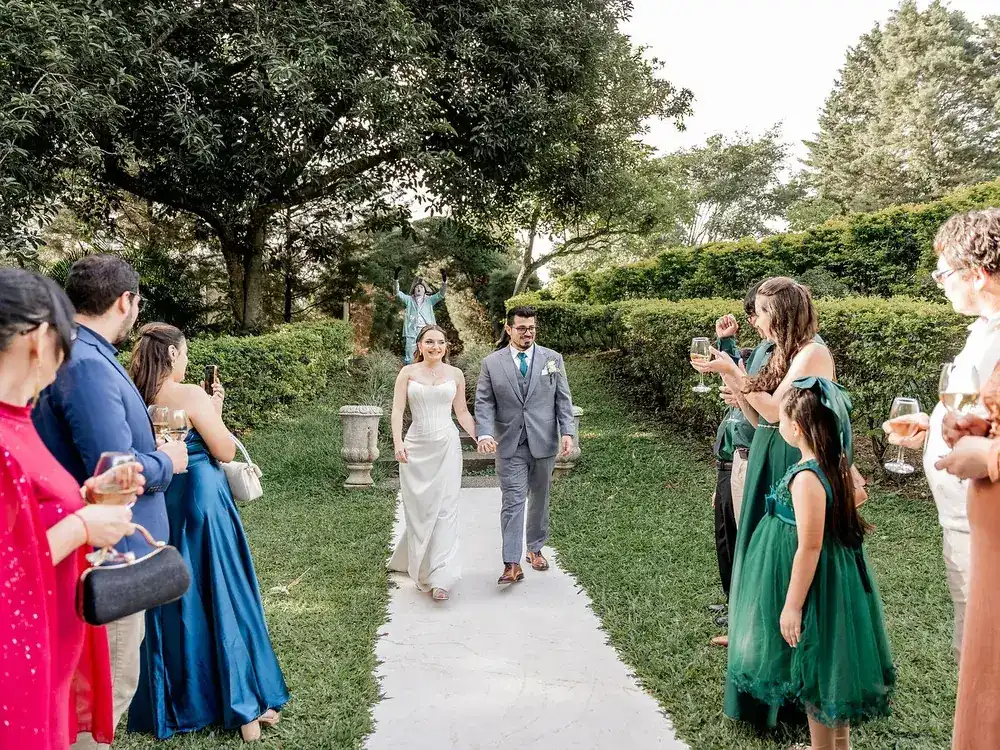 Novios saliendo entre los invitados por el sendero del jardín después de la ceremonia