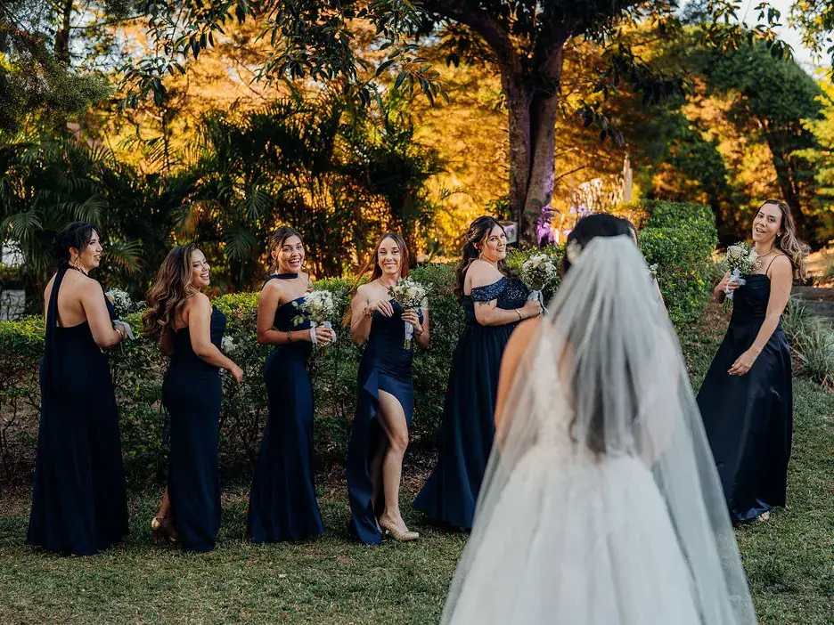 Grupo de invitadas en los jardines de Laureal con la luz dorada de la tarde