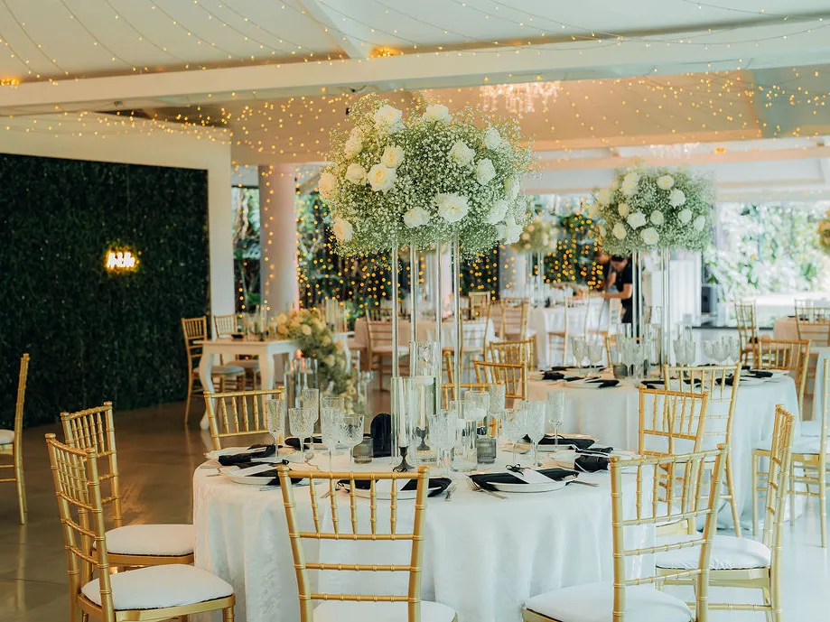 Salón de Laureal montado con mesas redondas y sillas tiffany doradas, apto también para reuniones y capacitaciones de empresa