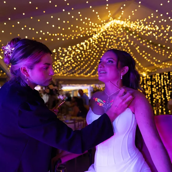 Novios abrazados bajo el cielo de luces cálidas del salón